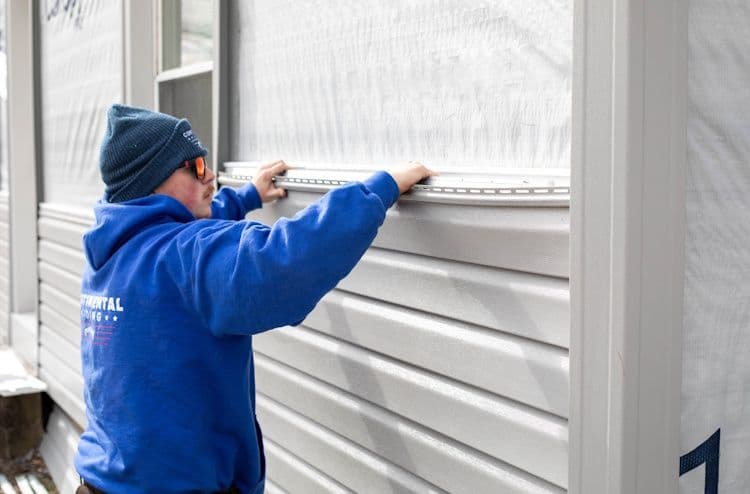 Worker measuring window frame with tape measure during home renovation installation
